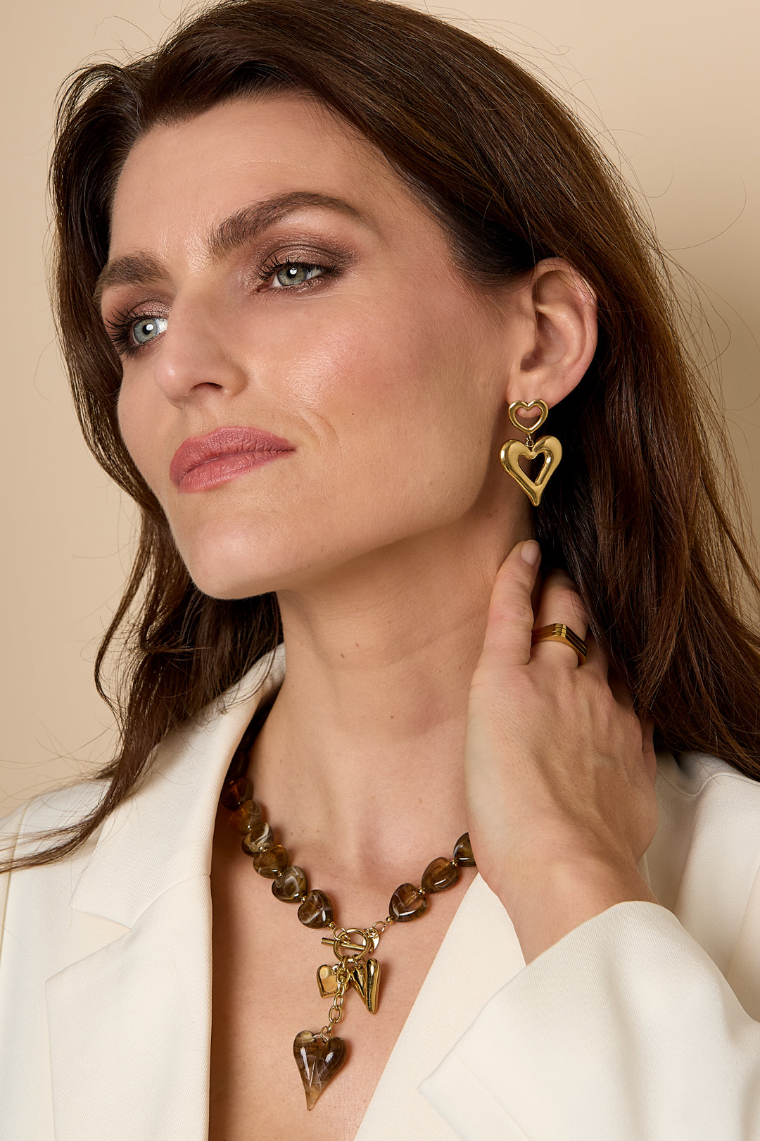 Gold heart drop earrings with a smaller heart above a larger heart.
