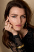 Woman wearing the Elara Bangle Bracelet, a thin gold band on her wrist.