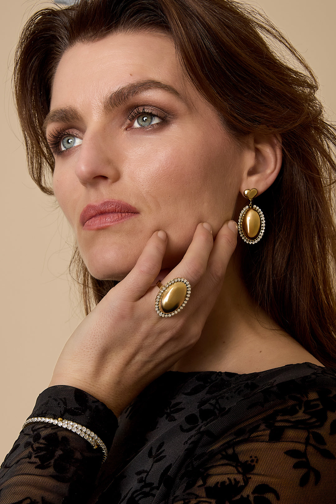 Gold oval statement earrings with rhinestones and a small gold heart top.