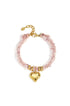 Gold heart charm on a pink textured bracelet with gold bead accents and a gold chain clasp.