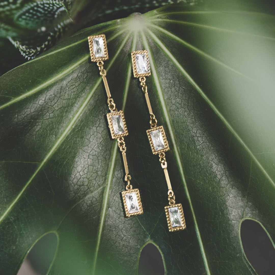 Elara Geometric Earrings: Gold-plated stainless steel drop earrings with clear rectangular zircon stones.