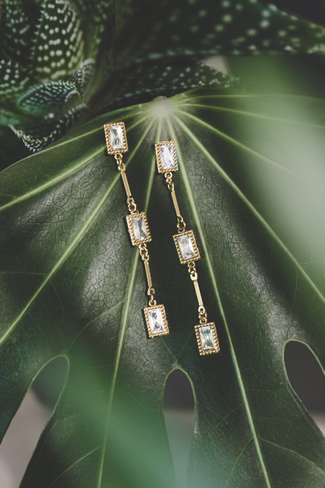 Elara Geometric Earrings: Gold-plated stainless steel drop earrings with clear rectangular zircon stones.