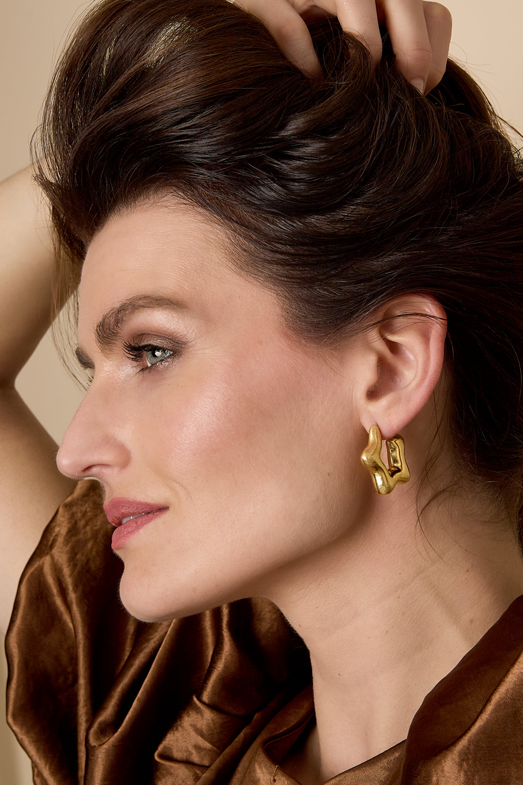 Gold celestial star hoop earrings with a unique, abstract shape.
