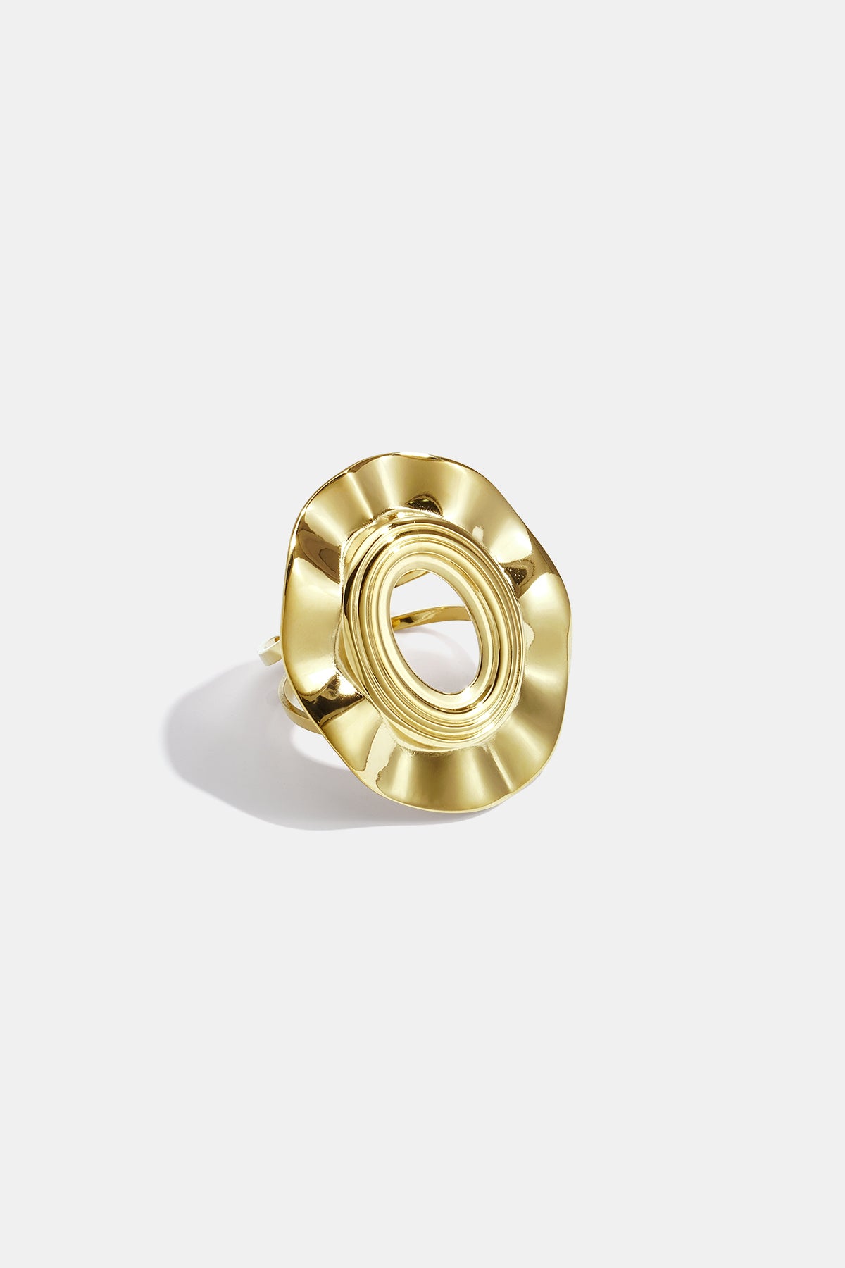 Irregular minimalist ring in gold with an oval center and wavy edges.