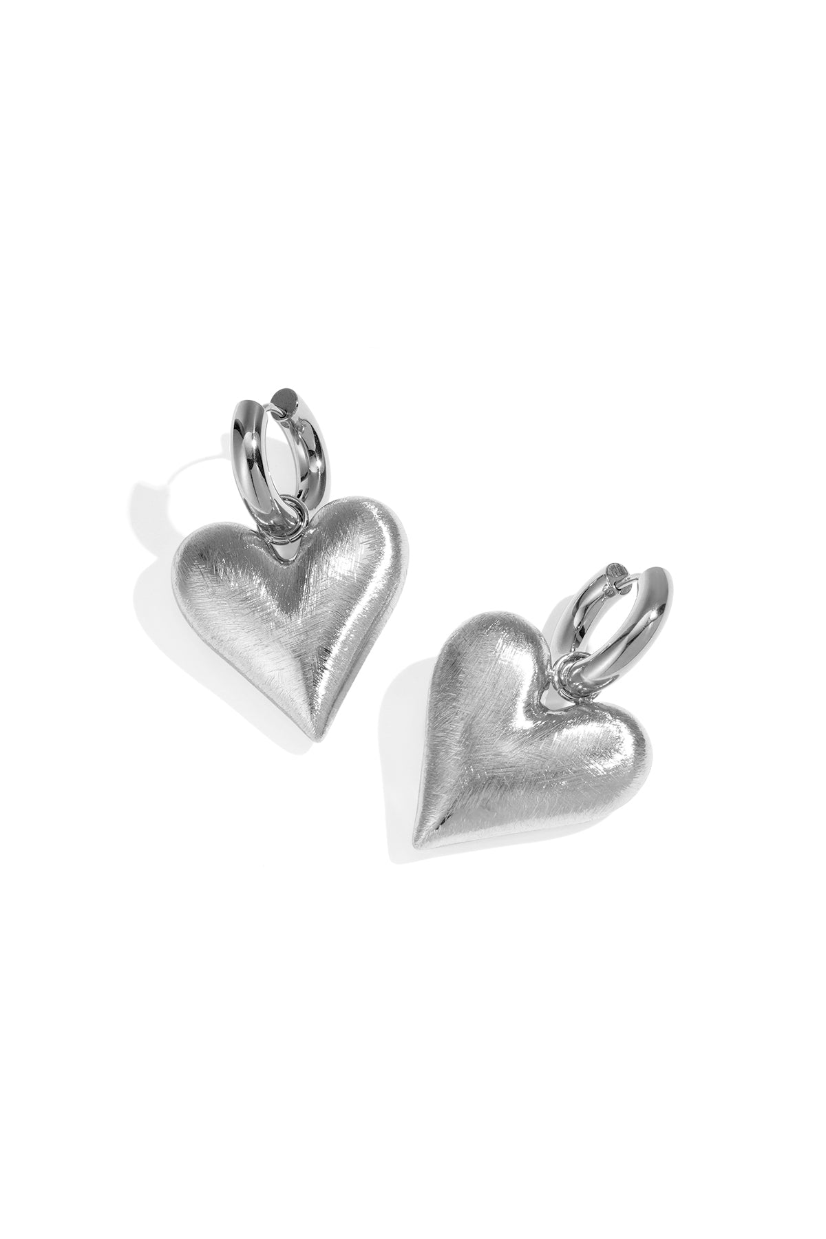 Silver heart drop earrings with a brushed finish and hoop closure.