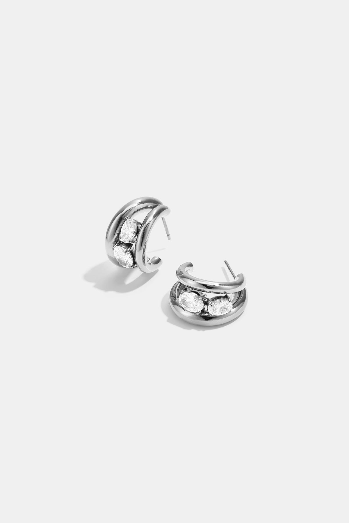 Silver hoop earrings with three clear oval stones on each earring.