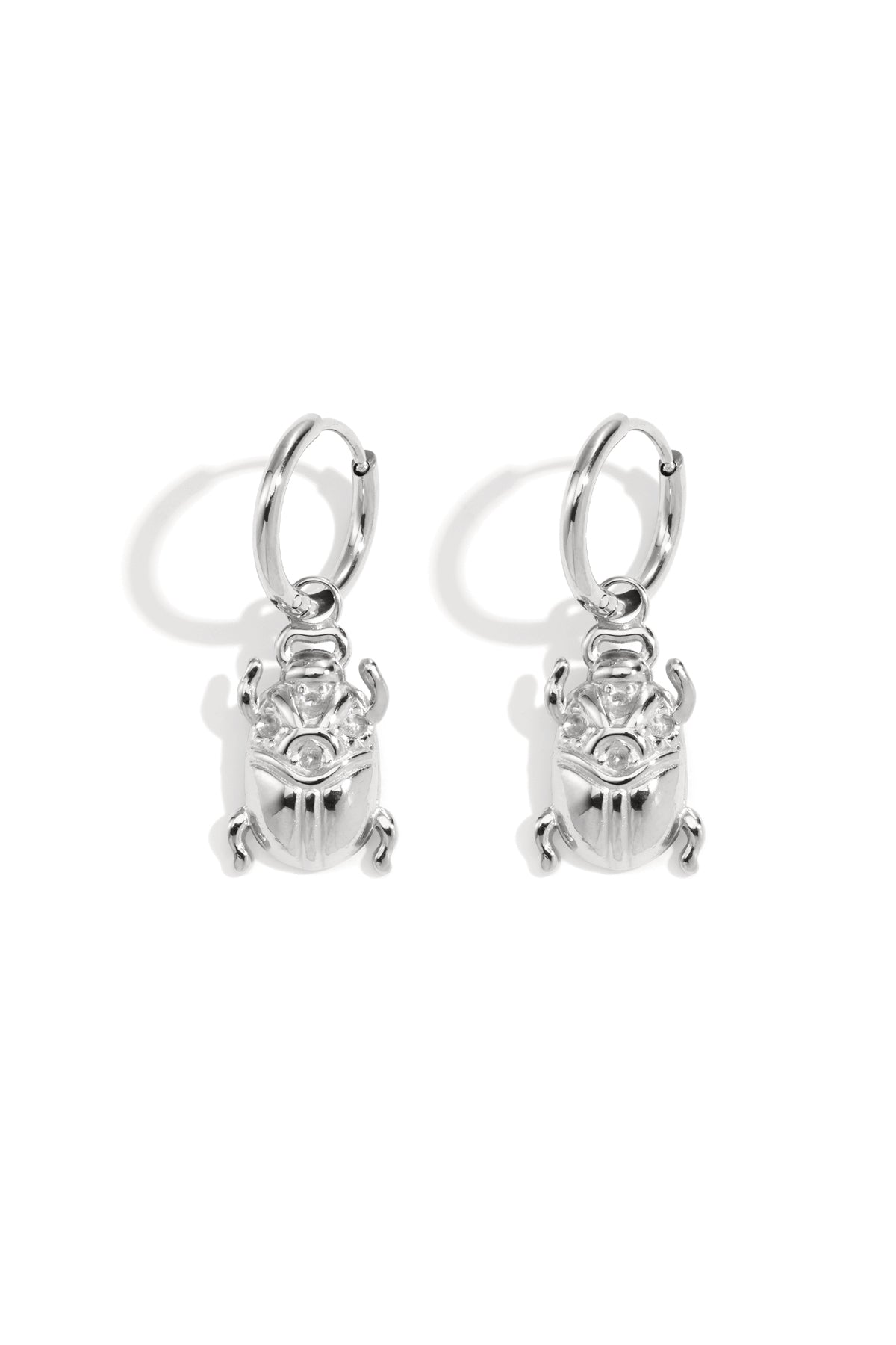 Silver hoop earrings with dangling scarab beetle charms.