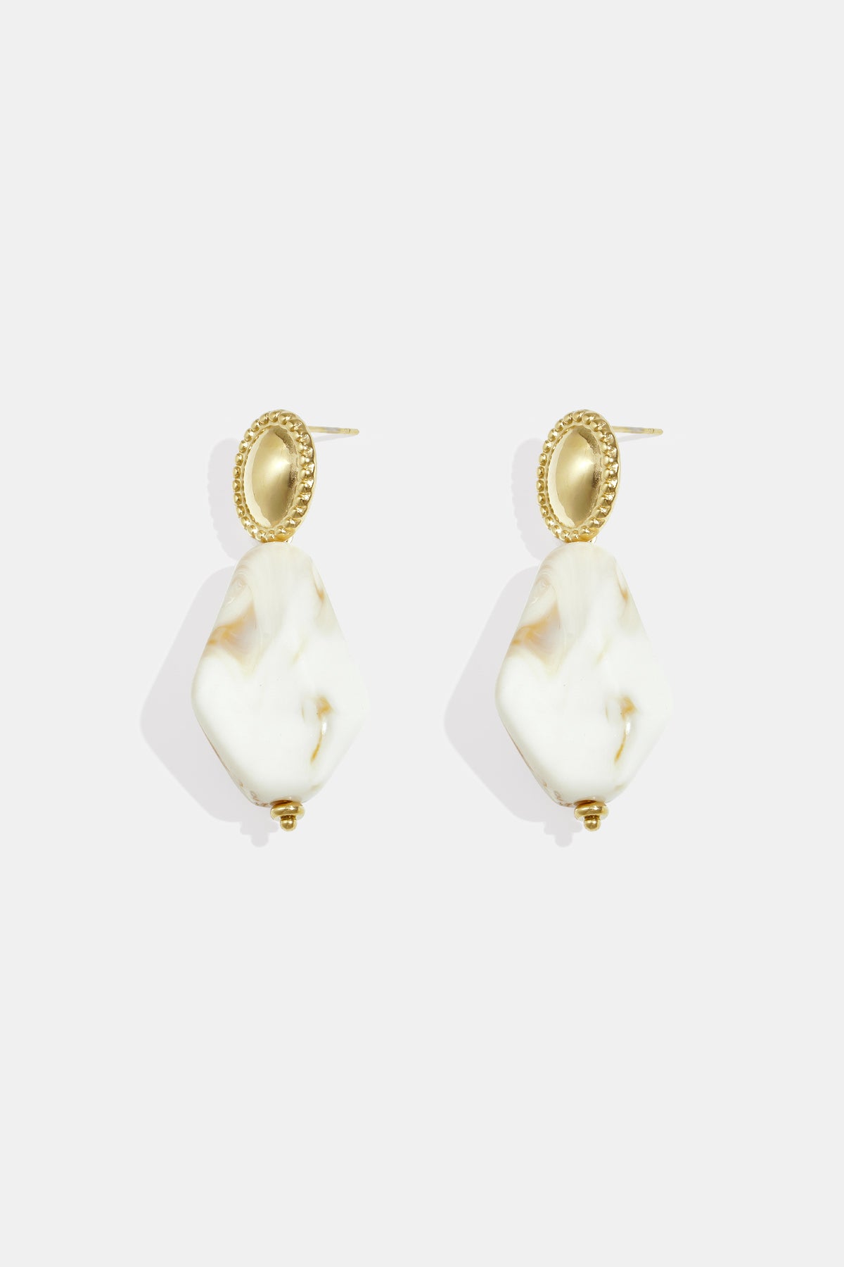 Gold stud earrings with oval textured tops and irregular white and amber marbled drop pendants.