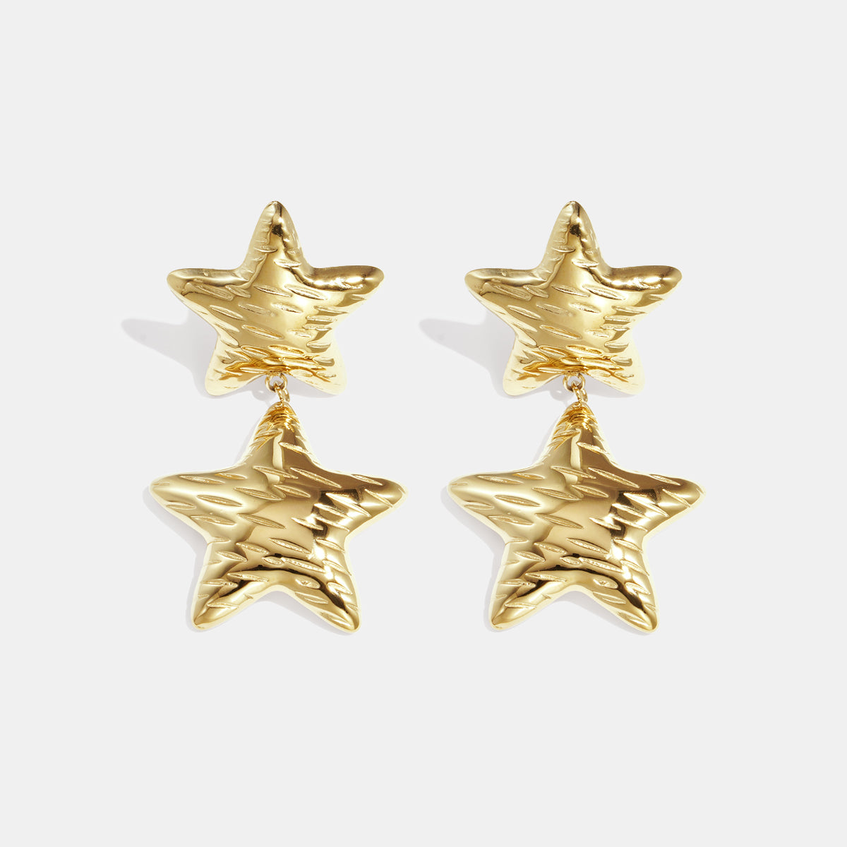 Gold celestial star drop earrings with textured surface, displayed against a white background.