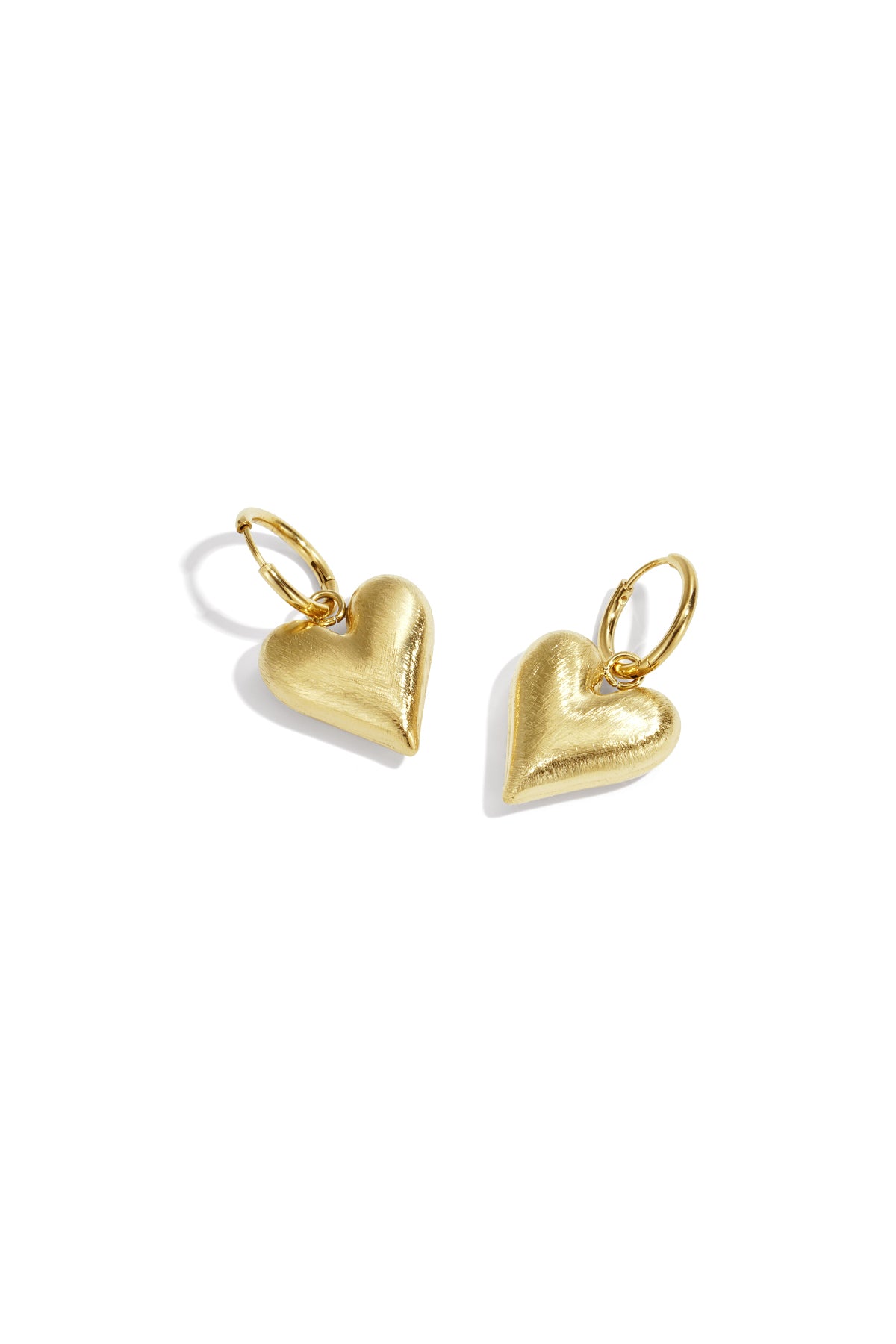 Gold heart drop earrings with hoop closures on a white background.