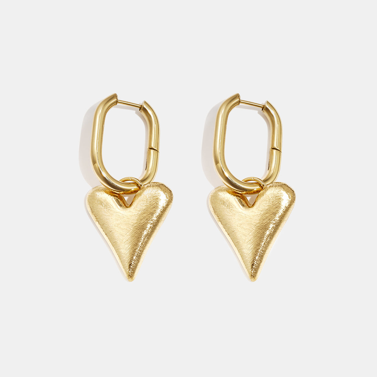 Gold heart drop earrings with oval hoops, brushed finish.