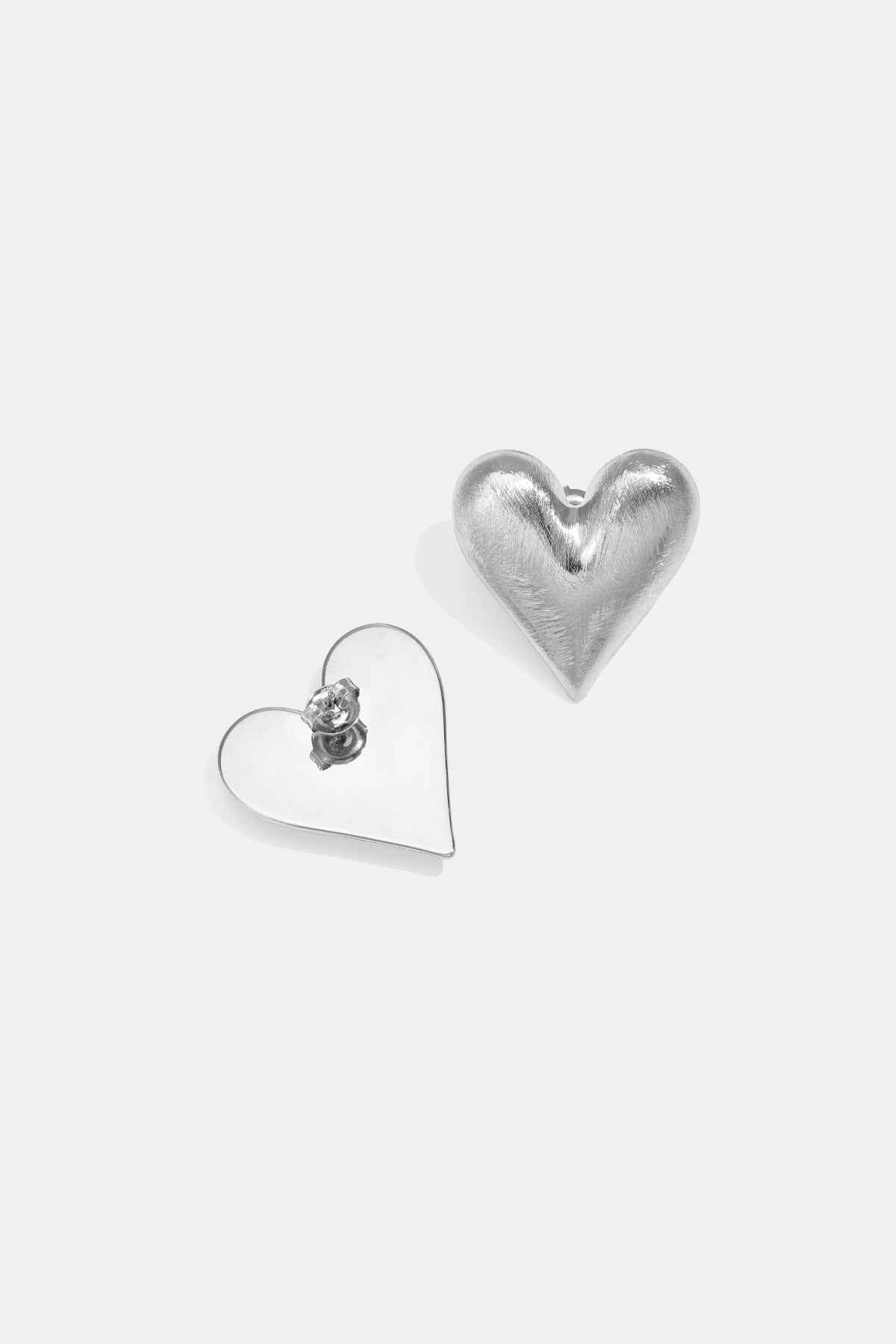 Two silver heart-shaped stud earrings on a white background.