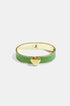 Gold bangle bracelet with a green enamel band and a gold heart charm.