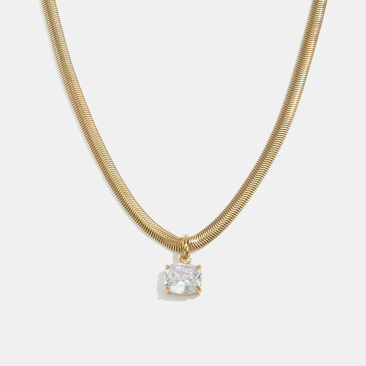 Gold herringbone chain necklace with a square-cut clear crystal pendant.