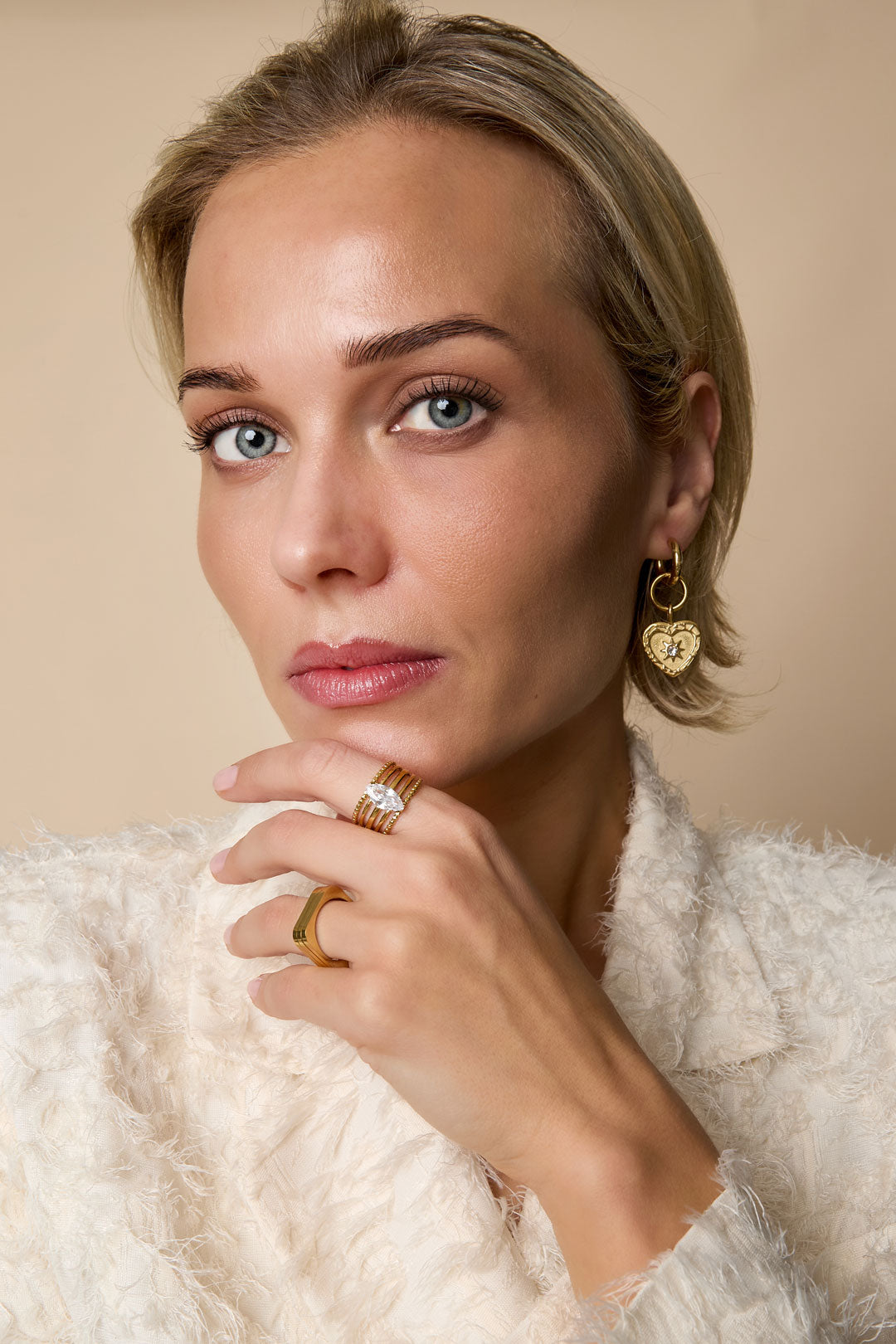 Gold-tone adjustable ring with a central marquise-cut zircon stone, worn on a woman's finger.