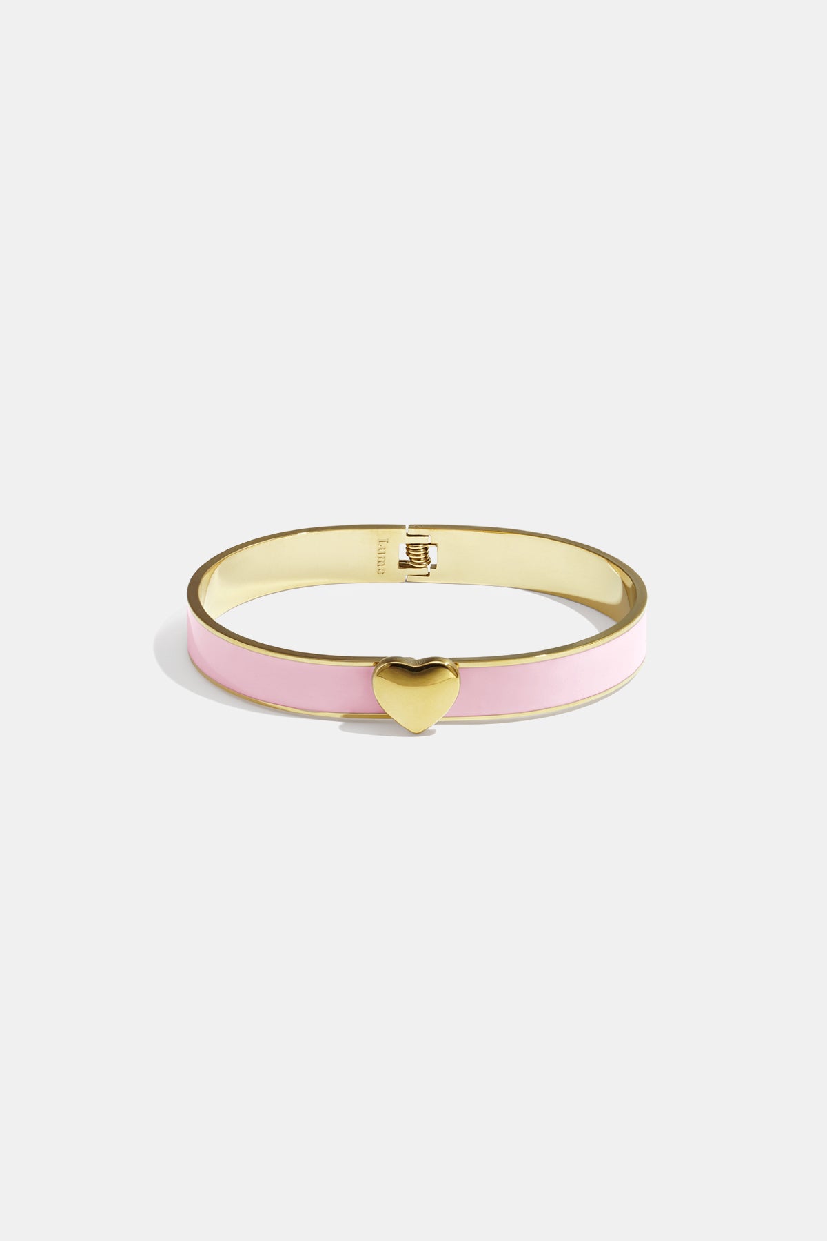 Gold bangle with pink enamel and a gold heart charm.