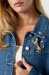 Gold leopard brooch with rhinestones on a denim jacket, with a butterfly and star brooch.