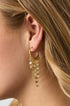Gold hoop earrings with multiple layers of delicate gold tassels hanging down.