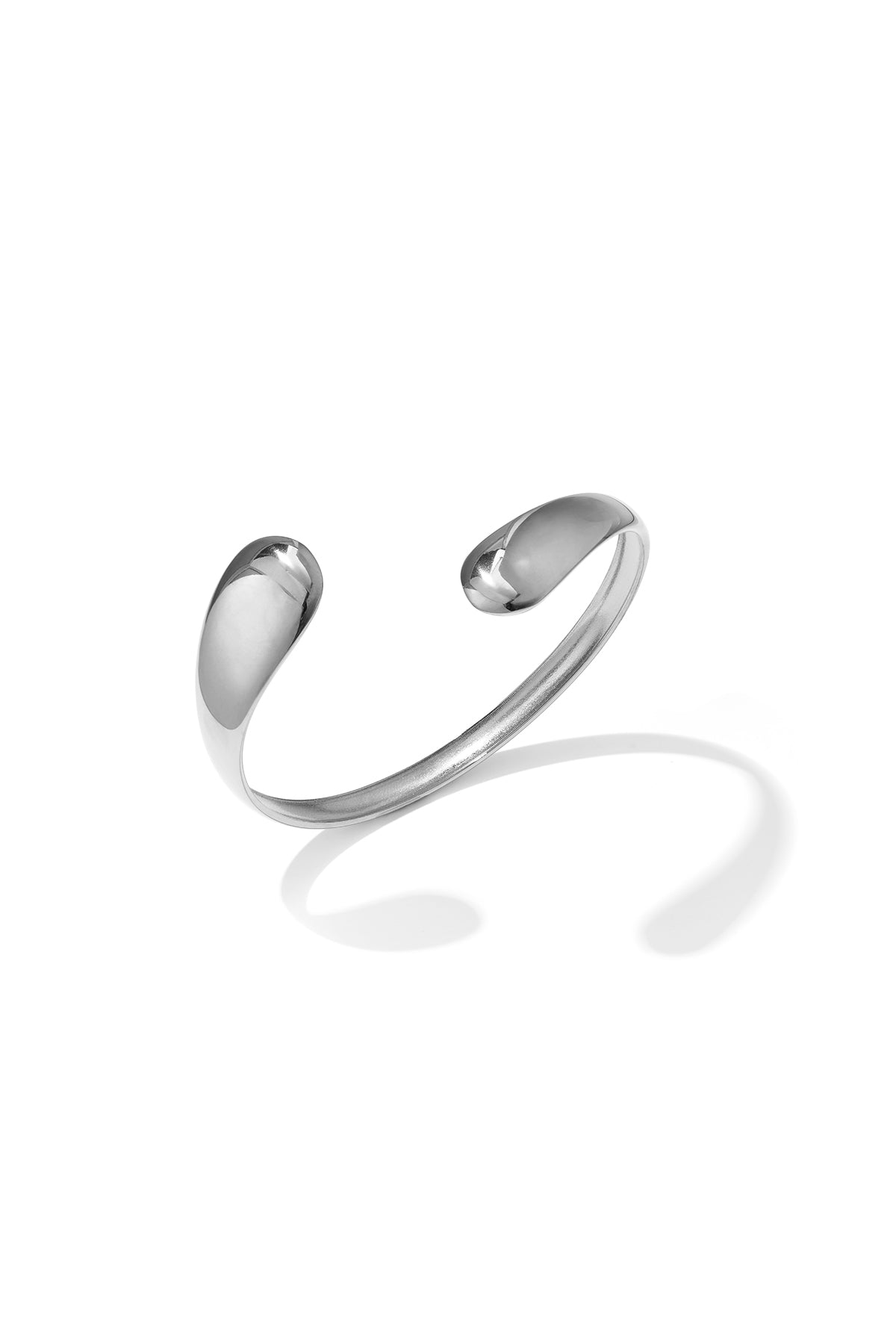 Silver irregular cuff bracelet with rounded ends, casting a shadow on a white background.