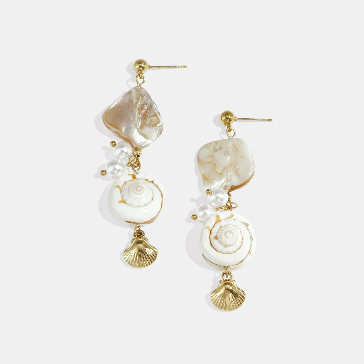Gold dangle earrings with shells, pearls, and spiral shell charms.