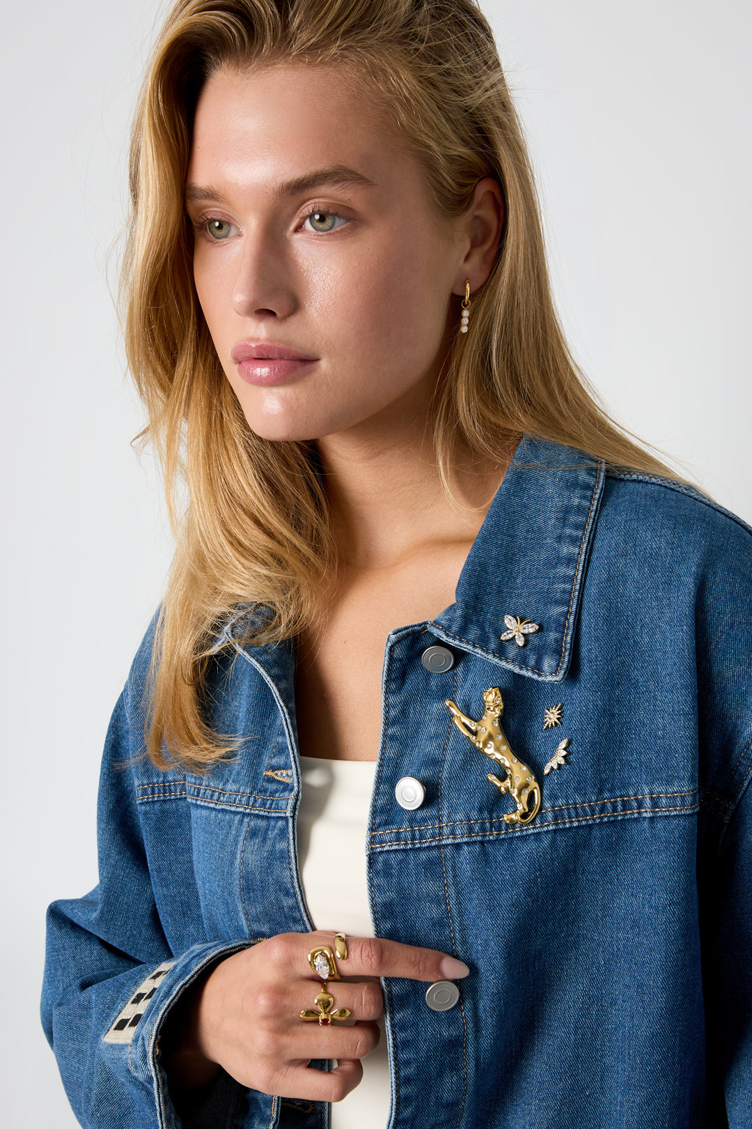 Gold leopard brooch with rhinestones on a denim jacket.