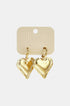 Gold heart drop earrings on a light beige card with "hume PREMIUM JEWELRY" printed on it.