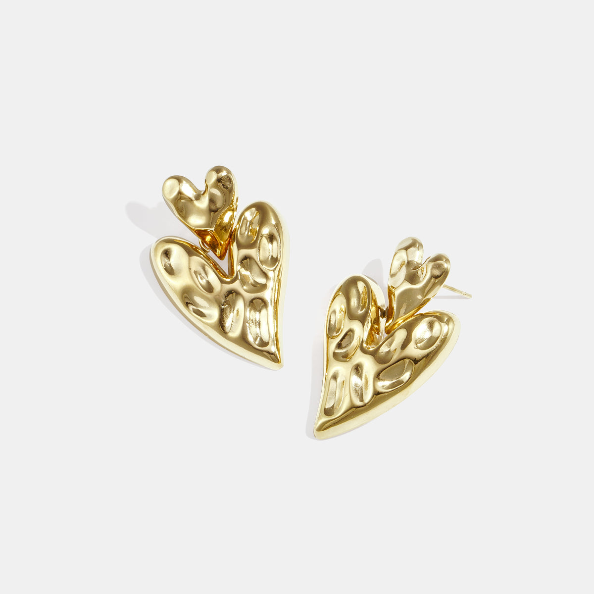 Gold stacked heart stud earrings with a textured finish.