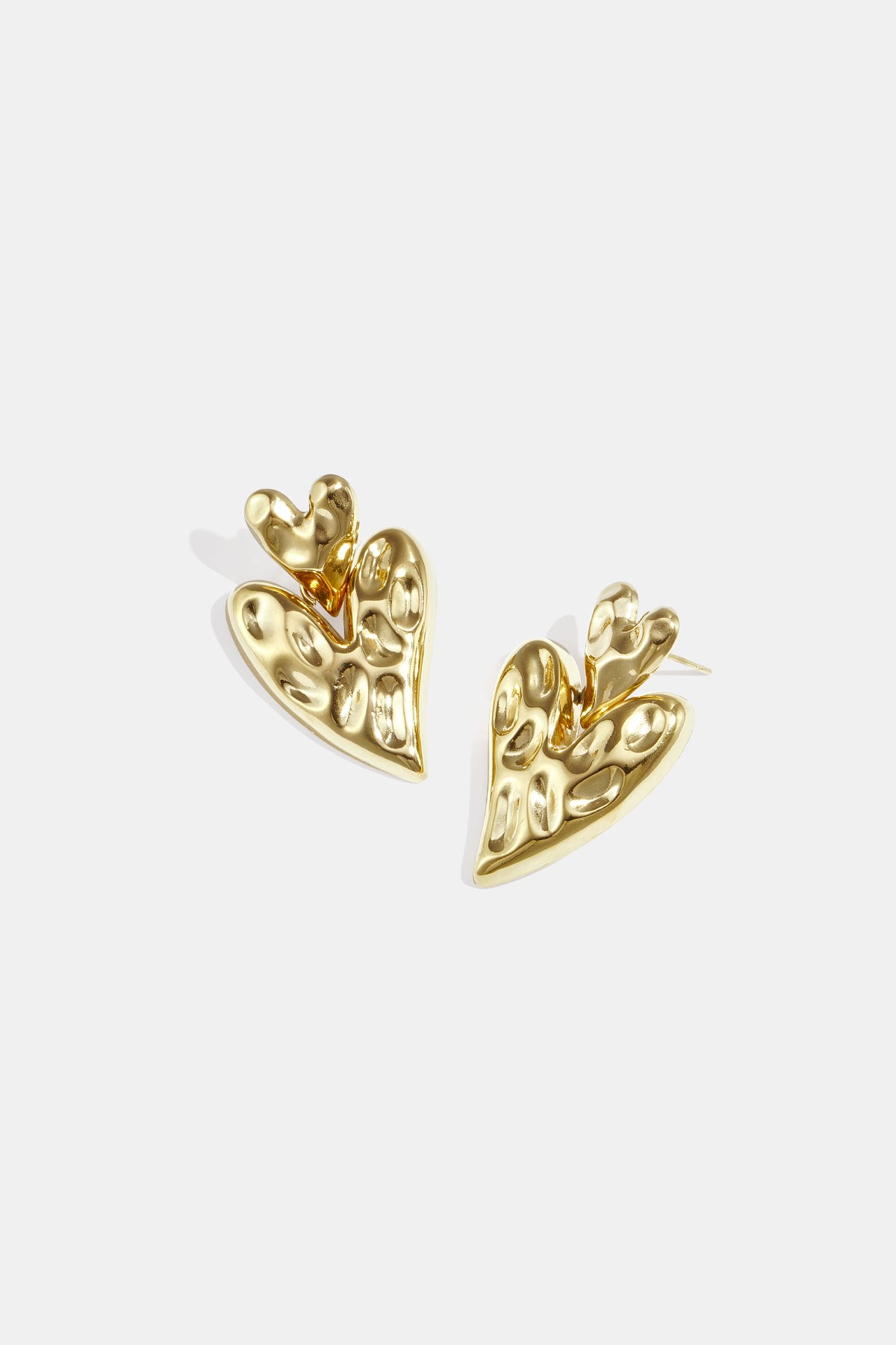 Gold stacked heart stud earrings with a textured finish.