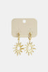 Gold sun drop earrings with pointed rays hanging from gold hoops on a cream backing card.