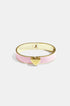 Gold bangle bracelet with pink enamel band and a gold heart charm.