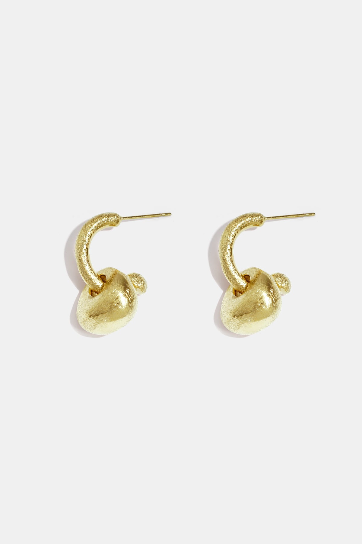 Gold-colored, matte finish drop earrings with irregular sculptural shapes.