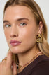 Gold heart drop earrings with a textured finish, worn by a model.