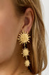 Gold dangle earrings with three sunburst charms of decreasing size.