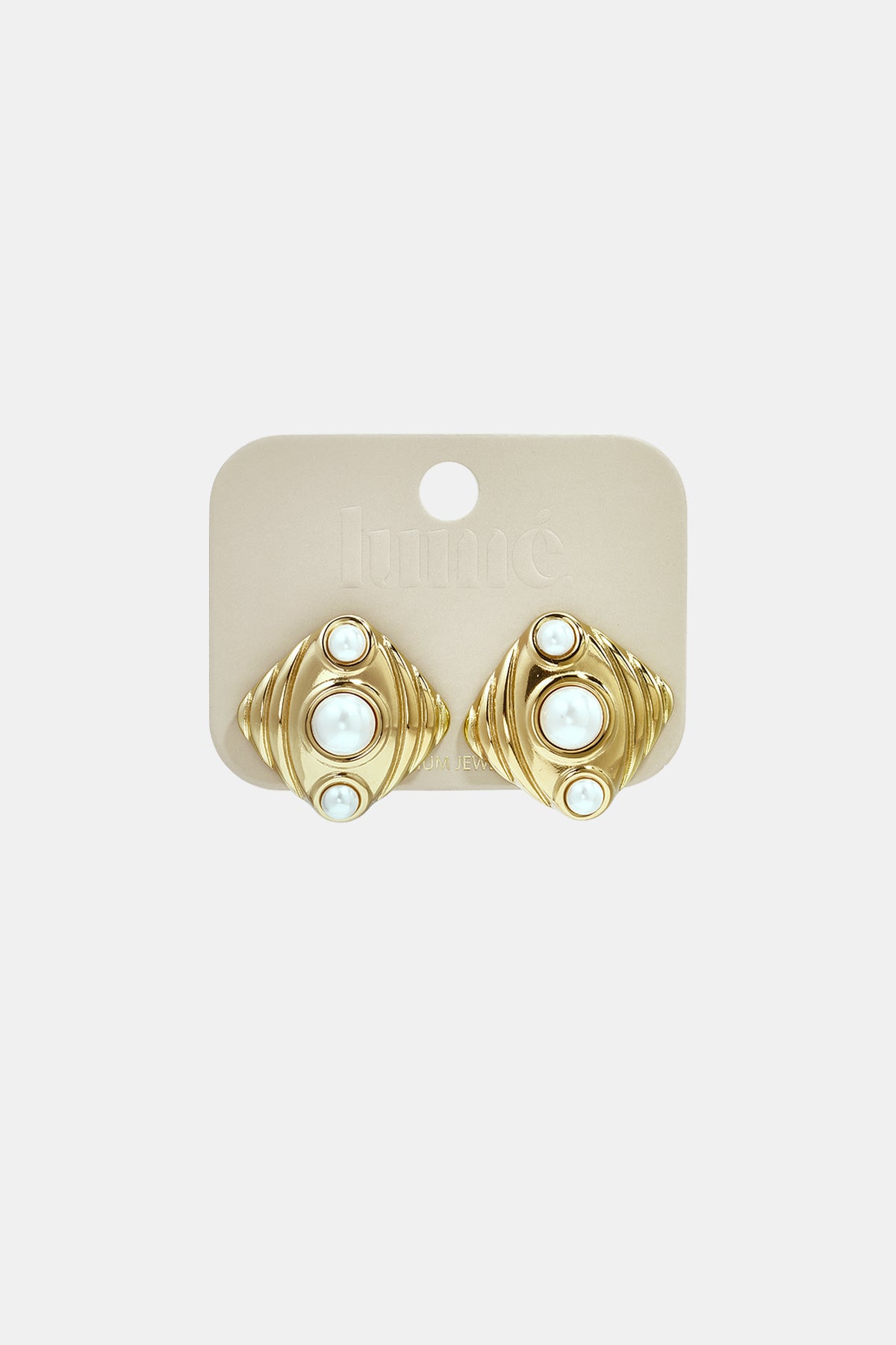 Gold geometric stud earrings with three pearls on a beige card.