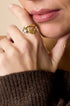 Gold ring with a heart shape and a zircon gemstone.