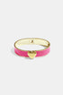 Gold bangle bracelet with a pink enamel band and a gold heart charm.