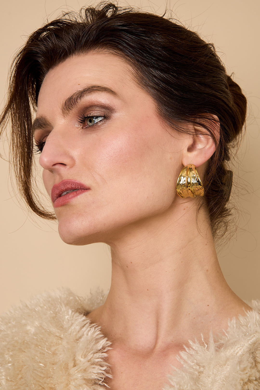 Gold Aurelia hoop earrings with a textured, leaf-like design.