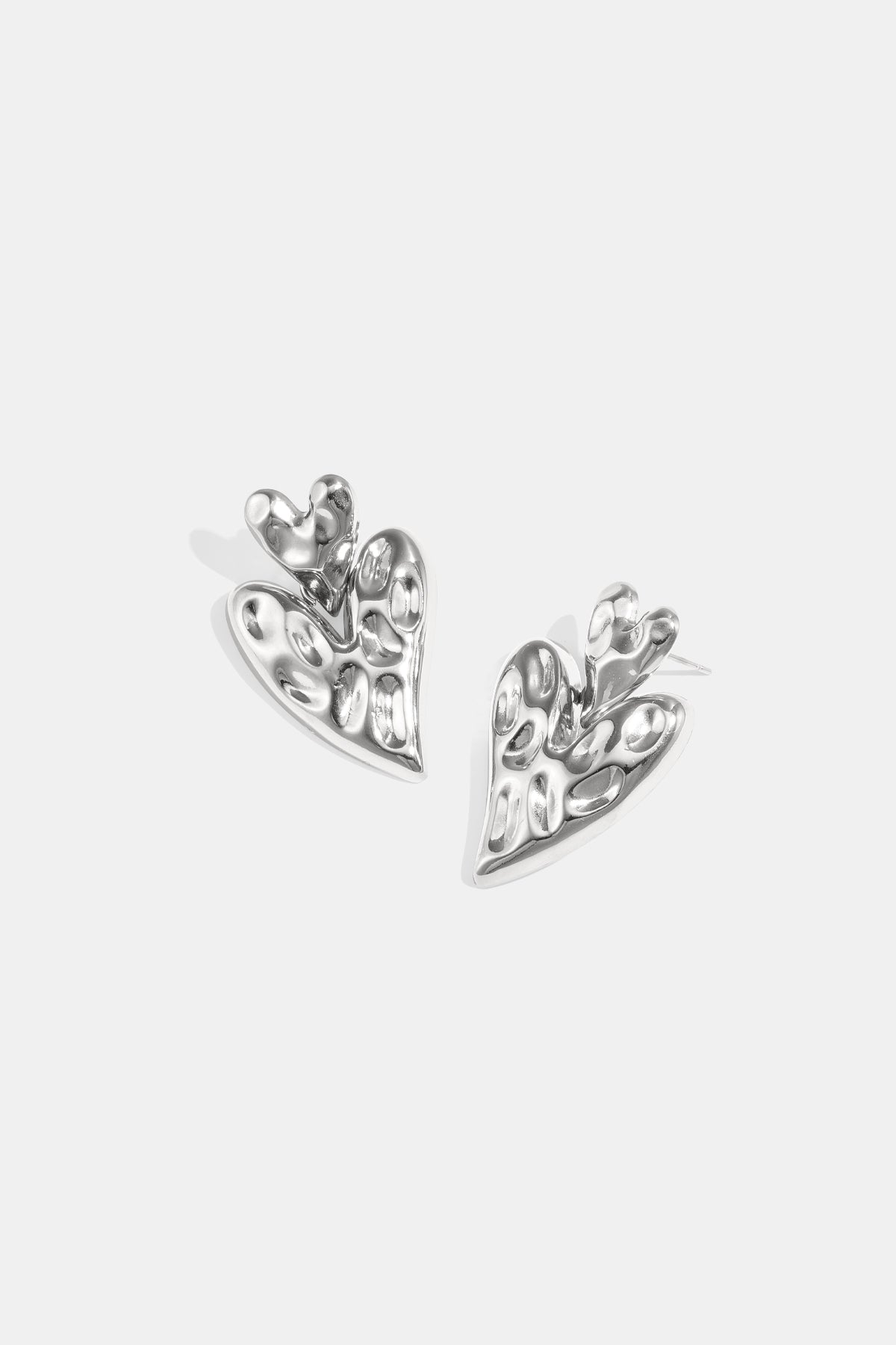 Silver stacked heart stud earrings with a textured finish.