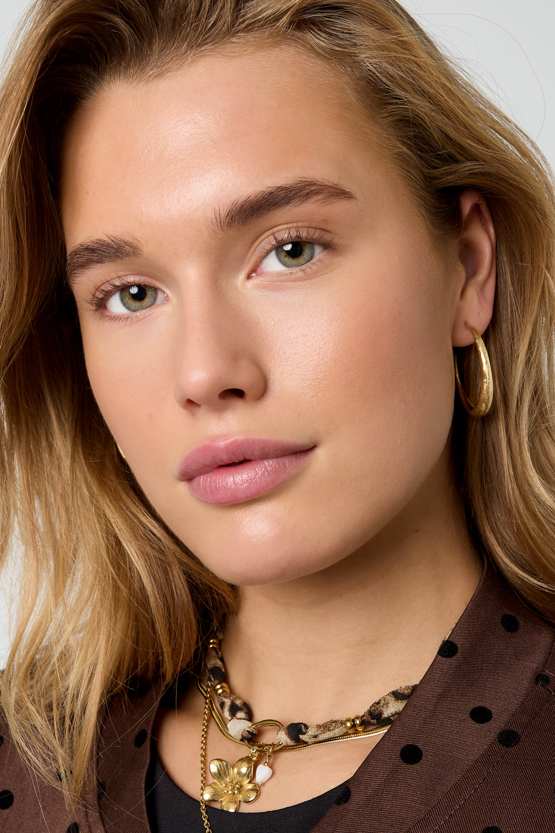 Aurelia Hoop Earrings in gold, worn by a model.
