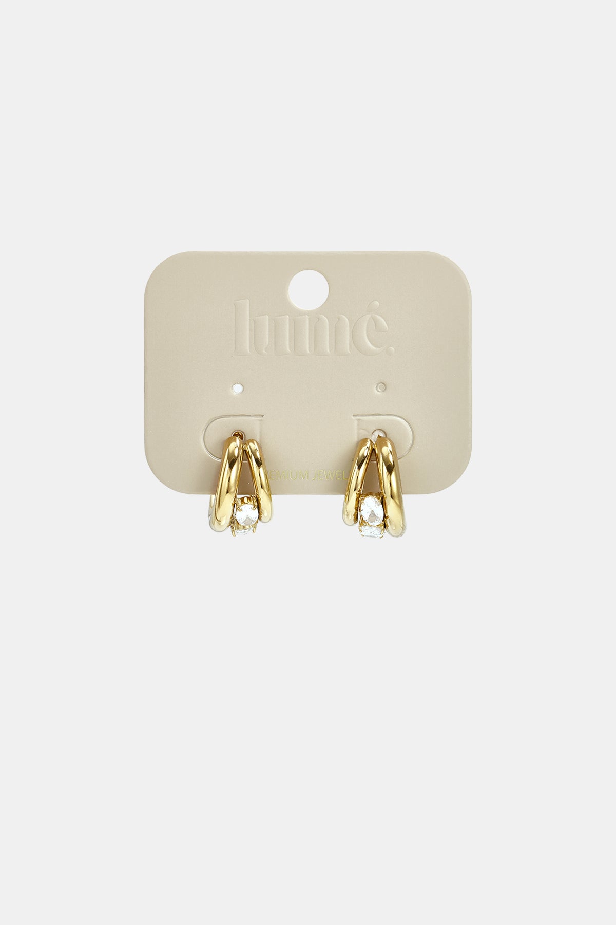 Gold hoop earrings with clear stones on a light beige card.