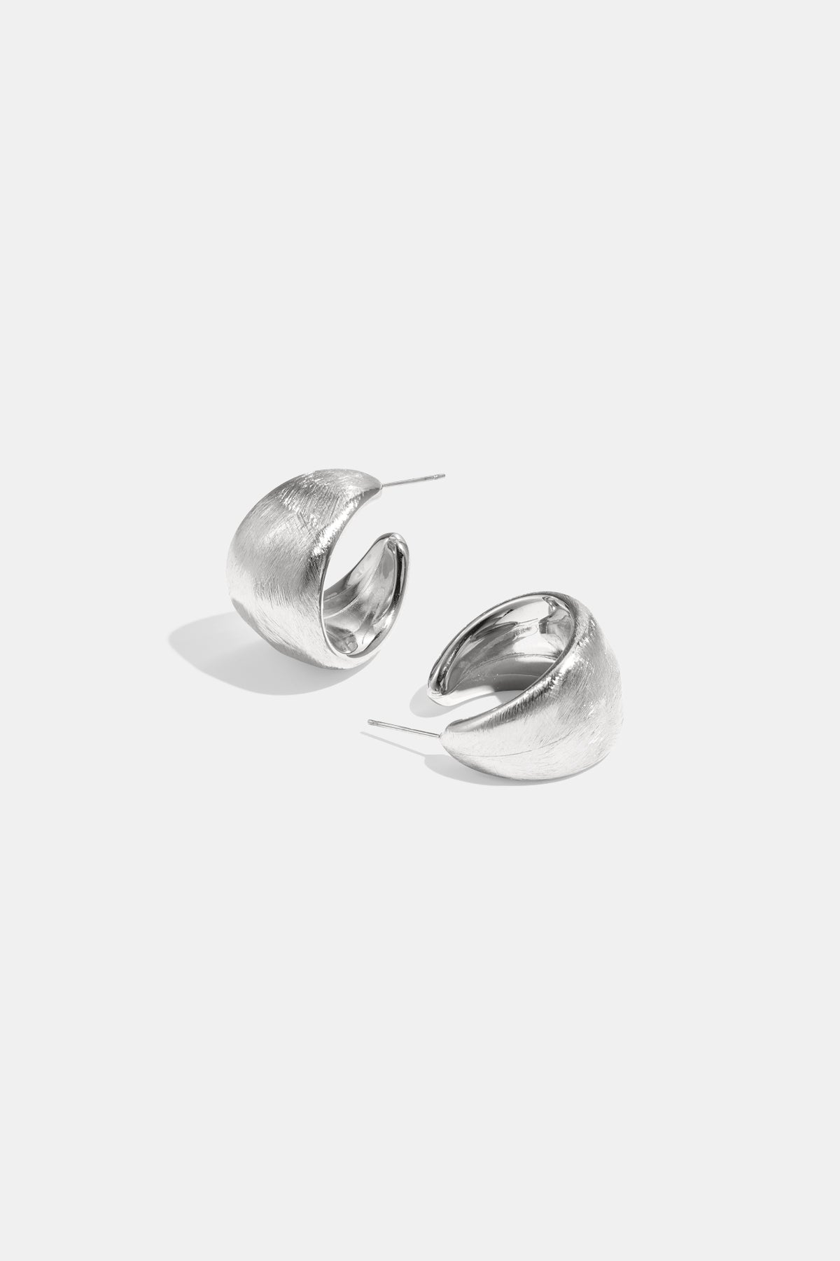 A pair of brushed silver Aurelia hoop earrings on a white background.
