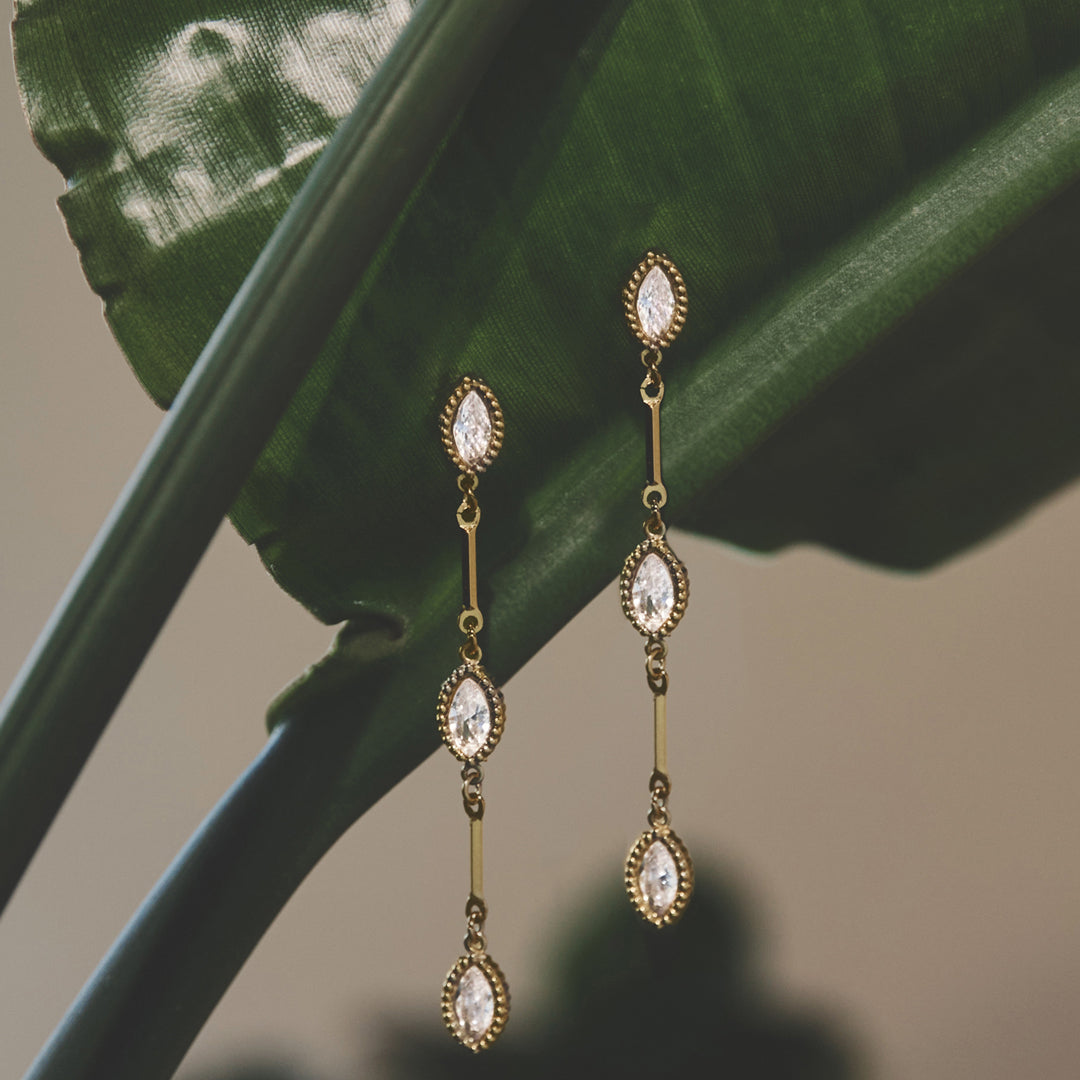 Celeste Dangle Earrings with three marquise-cut clear stones and gold-tone metal.