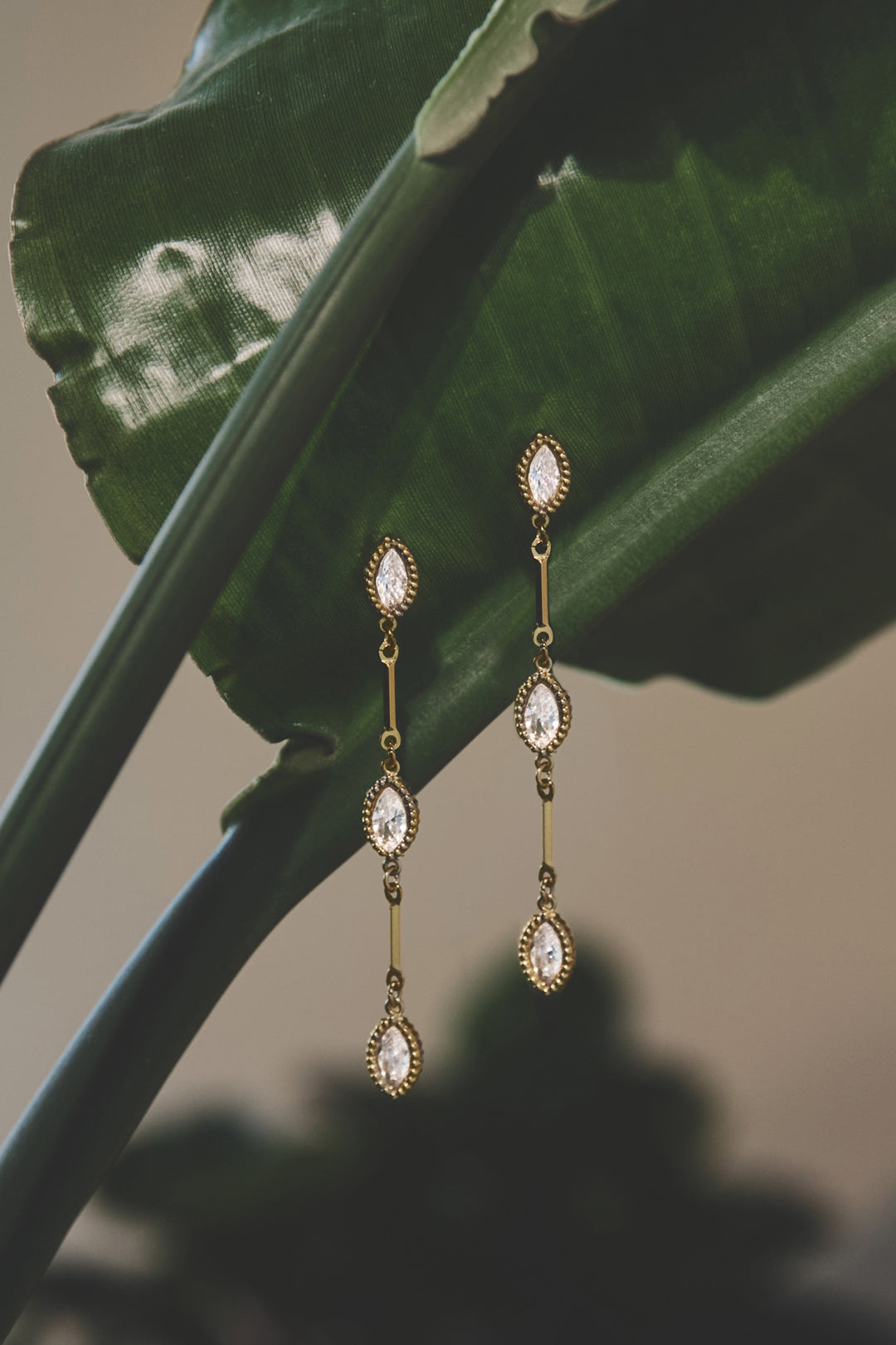 Celeste Dangle Earrings with three marquise-cut clear stones and gold-tone metal.