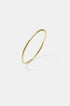 Gold-toned 3 mm wide brushed finish bangle bracelet with a subtle texture.