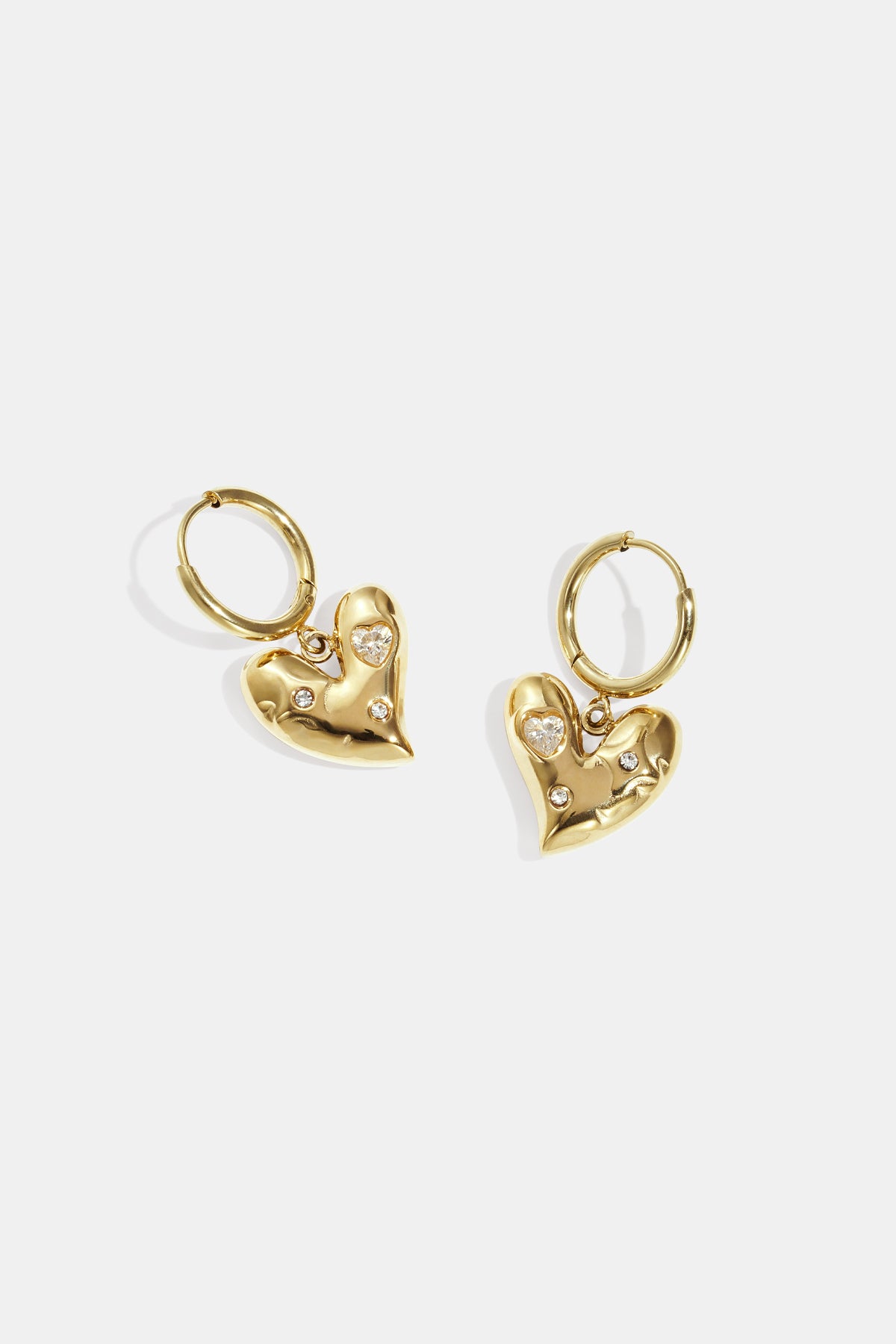 Gold heart-shaped drop earrings with small rhinestones and a gold hoop.