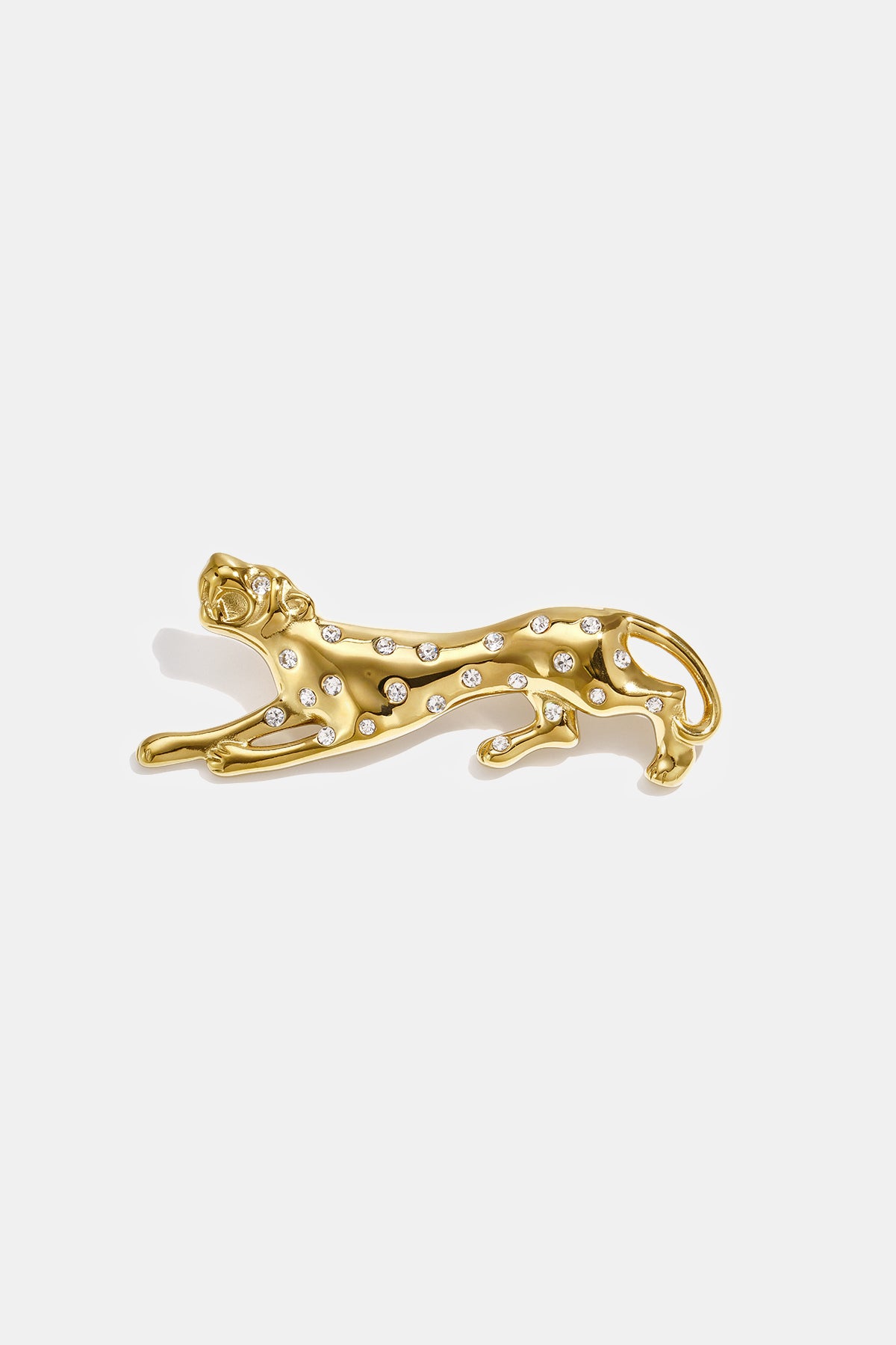 Gold-colored cheetah brooch with clear rhinestones, lying down.