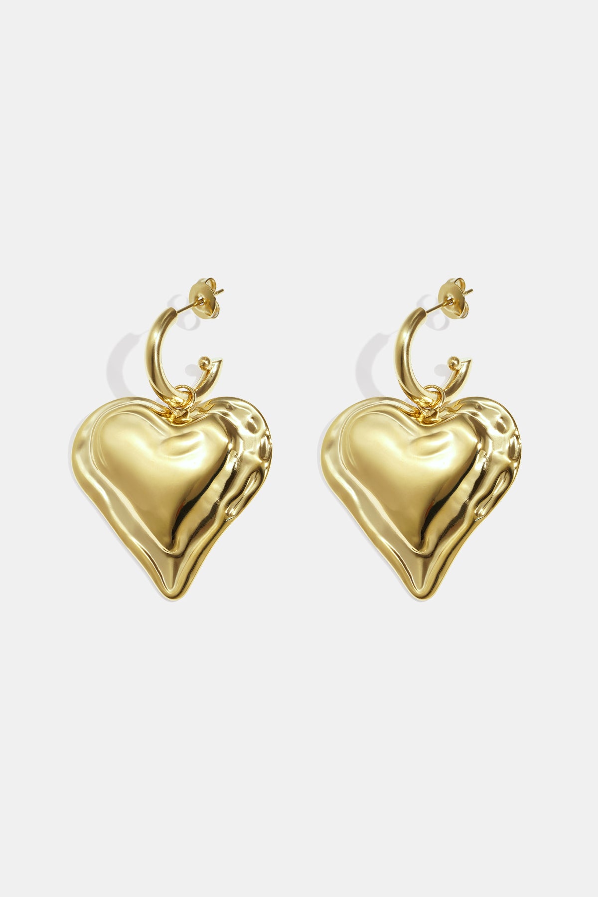 Gold heart drop earrings with a textured surface, attached to a hoop.
