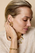 Aurelia Circle Stud Earrings in gold, worn by a model.