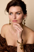 Beaded bracelet with brown heart charms and gold accents, worn on a woman's wrist.
